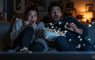 Scared couple jumping out of their seat while watching a horror movie
